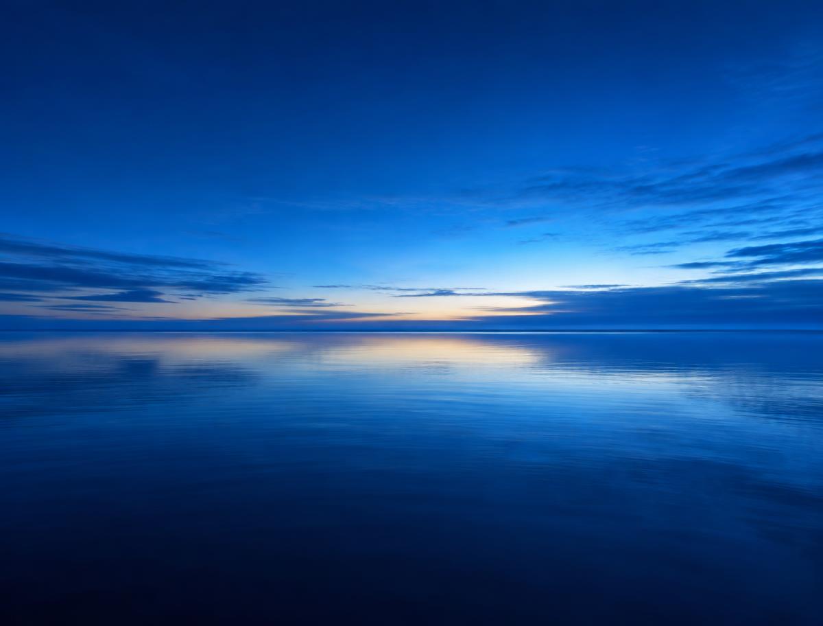 Calm blue ocean meeting a blue sky at the horizon